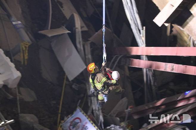 [광명=뉴시스] 12일 오전 4시27분 경기 광명시 일직동 신안산선 복선전철 5-2공구 붕괴 현장에 고립됐던 작업자를 소방관이 구조하고 있다. (사진=경기도소방재난본부 제공) 2025.4.12. photo@newsis.com *재판매 및 DB 금지