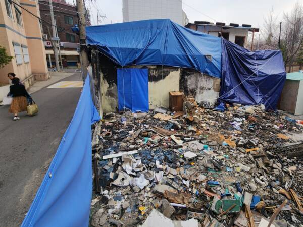 12일 오전 인천 부평구 부평공원 인근에서 시민들이 방치 중인 화재 잔해 옆을 지나가고 있다. 황남건기자