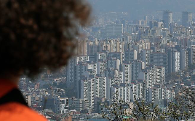 한 시민이 서울 시내 아파트 밀집 지역을 바라보고 있다. 주요 재건축 단지와 고가 아파트가 몰린 지역을 중심으로 토지거래 허가 건수가 매년 증가하고 있다. 뉴스1
