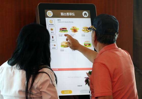 지난해 8월 부산 부산진구 롯데호텔에서 보훈대상자 어르신이 키오스크로 음식을 주문하는 방법을 배우고 있는 모습. [뉴스1]