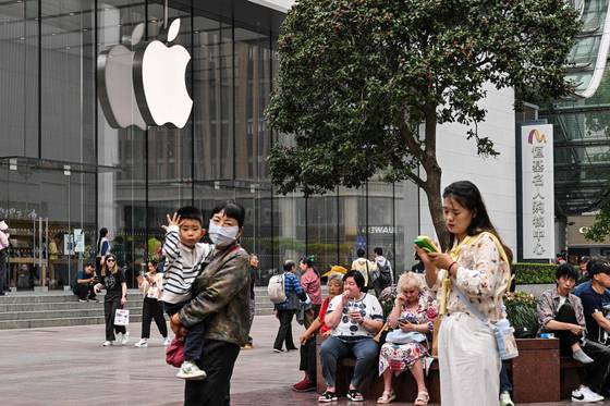 지난 11일 중국 상하이에 있는 애플 매장 앞을 사람들이 지나가고 있다. AFP=연합뉴스