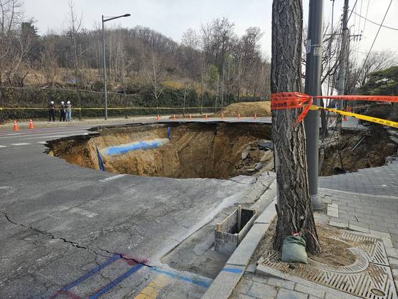 지난달 26일 서울 강동구 명일동에 발생한 직경·깊이 20m의 싱크홀. 해당 사고로 오토바이를 몰던 30대 남성이 도로 아래로 떨어져 숨졌다. 이수민 기자