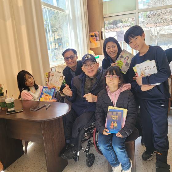 고정욱 작가는 지난달 대전에서 찾아온 어린이 팬 가족과 따뜻한 미소로 인사를 나누며 소중한 추억을 사진으로 담았다. 배현정 기자