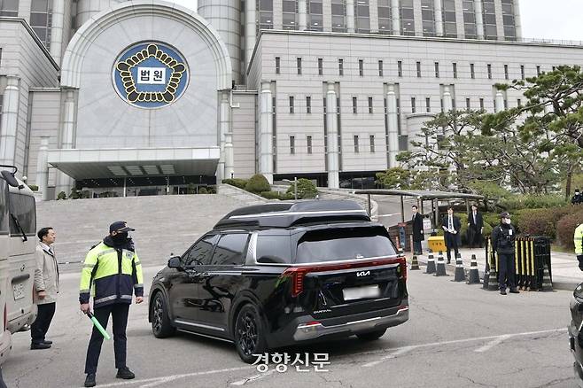 윤석열 전 대통령의 내란 혐의 첫 형사 재판이 열리는 14일 서울중앙지방법원으로 윤 전 대통령이 탑승한 차량이 들어가고 있다. 사진공동취재단