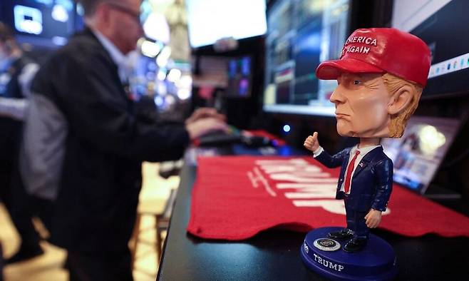 14일 도널드 트럼프 미국 대통령을 묘사한 인형이 뉴욕 증권거래소(NYSE) 개장 종이 울리는 시각에 뉴욕시 거래소 내부에서 책상 위에 놓여 있다. 뉴욕/AFP 연합뉴스