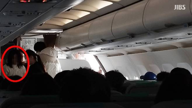 항공기 비상문을 강제 개방한 30대 여성 A 씨가 항공사 직원에 제지되는 모습 (사진, 시청자 제공)
