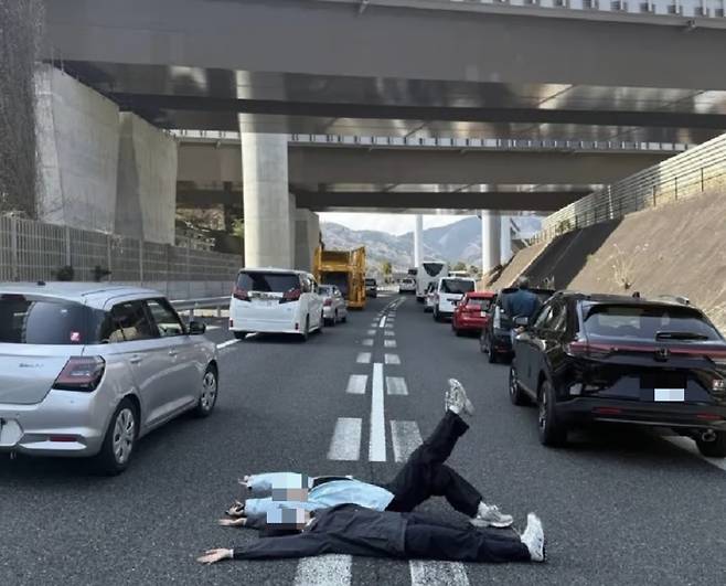 일본의 한 고속도로에서 관광버스 충돌 사고로 교통이 정체된 틈을 타 고속도로 위에 누워 이른바 '인생 사진'을 찍은 중국인 여성들이 비난 받고 있다./사진=X(옛 트위터)