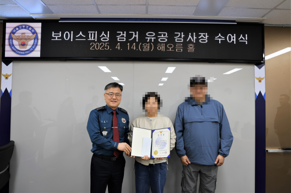 보이스피싱 수거책 검거에 기여한 택시기사 부부가 지난 14일 서울 강동경찰서에서 감사장을 받은 뒤 기념촬영을 하고 있다. 보이스피싱 조직의 보복 등을 우려해 부부의 얼굴은 모지이크 처리했다. 강동경찰서 제공