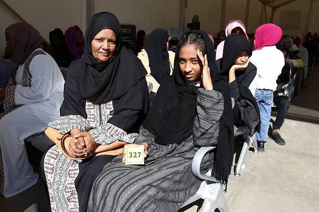이집트 유엔난민기구(UNHCR) 난민등록센터서 차례 기다리는 수단 난민 모녀 (카이로=연합뉴스) 성도현 기자 = 지난달 23일(현지시간) 이집트 카이로 인근 유엔난민기구(UNHCR) 난민등록센터를 찾은 수단 난민 마샤어 세이겔딘(왼쪽) 씨와 막내딸 로아 살라(오른쪽) 양이 난민 신청 절차를 위해 대기 번호표를 받고 기다리고 있다. 2025.4.15 raphael@yna.co.kr