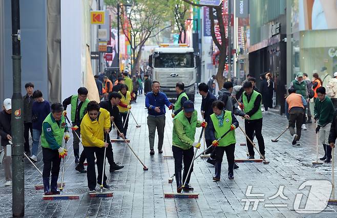 명동주민센터와 롯데백화점, 명동관광특구 상인회, 자원봉사자, 명동 복지회 관계자 등이 16일 오전 서울 중구 명동관광특구 일대에서 2025년 봄맞이 명동 거리 대청소를 하고 있다.  2025.4.16/뉴스1 ⓒ News1 박정호 기자
