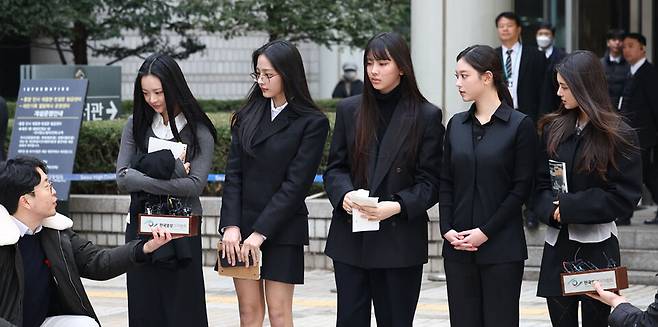 ​걸그룹 뉴진스(NJZ)가 7일 서울 서초구 서울중앙지방법원에서 열린 '기획사 지위보전 및 광고계약 체결 등 금지' 가처분 신청의 심문기일을 마친 뒤 법원 청사를 나서며 취재진 질문에 답하고 있다.왼쪽부터 하니, 민지, 혜인, 해린, 다니엘. ⓒ연합뉴스​