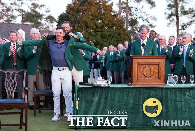 로리 맥길로이가 14일 마스터스토너먼트에서 우승한 뒤 지난해 챔피언 스카티 셰플러의 도움으로 그린 재킷을 입고 있다./신화.뉴시스