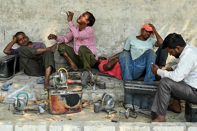15일 인도 펀자브주 암리차르에서 더위를 피해 휴식을 취하고 있는 시민들. /AFP 연합뉴스