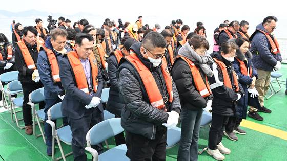 세월호 참사 11주기를 맞은 16일 오전 전남 진도군 맹골수도에서 열린 선상추모식 도중 0416단원고가족협의회 세월호 유족이 희생자를 기리며 묵념하고 있다. 뉴시스