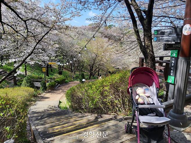 유아차가 15일 서울 서대문구 안산벚꽃길 계단 앞에 서 있다.  계단 아래 홍제천 방향 산책로는 계단 때문에 유아차가 내려가기 어렵다. 김태욱 기자