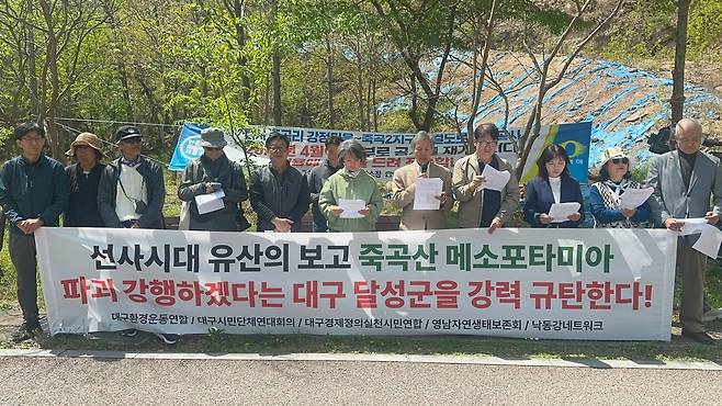 대구지역 환경단체 등이 연대한 ‘두물머리 죽곡산 선사유적공원 추진위원회’ 관계자들이 16일 달성군 다사읍 죽곡리 도로 건설 예정지 앞에서 공사 방침을 비판하고 있다. 대구환경운동연합 제공