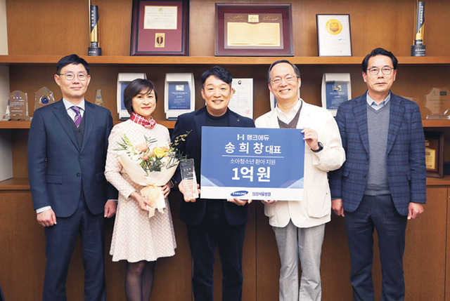 송희창(왼쪽 세 번째) 씨가 지난 2023년 수술비가 없어 치료를 받지 못하는 소아·청소년 환아 지원을 위해 삼성서울병원에 1억 원을 기부하고 난 뒤 기념사진을 찍고 있다.  초록우산 제공