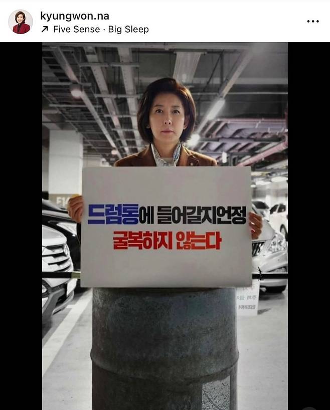 국민의힘 나경원 의원이 드럼통 안에 들어가 서서민의힘 나경원 의원이 드럼통 안에 들어가 서서 ‘드럼통에 들어갈지언정 굴복하지 않는다’는 문구가 적힌 피켓을 들고 있는 사진. [나경원 의원 SNS]