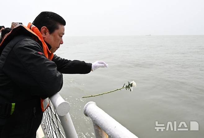 [진도=뉴시스] 김혜인 기자 = 세월호 참사 11주기인 16일 오전 전남 진도군 맹골수도에서 열린 선상추모식 중 세월호 참사 유족이 사고 해역에 희생자를 추모하는 국화를 헌화하고 있다. 2025.04.16. hyein0342@newsis.com