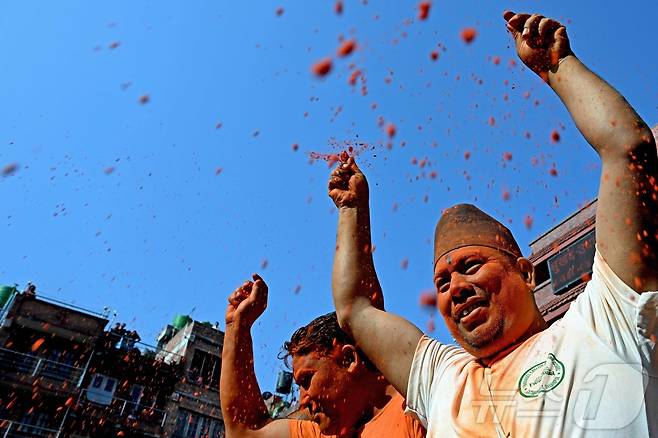 15일(현지시간) 네팔 카트만두에서 열린 신두르 자트라 축제에서 시민들이 주홍 가루를 뿌리며 축제를 즐기고 있다. ⓒ AFP=뉴스1