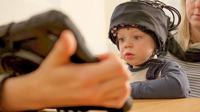 연구진은 영유아의 뇌가 중요한 능력을 어떻게 키우는지 알아내고자 특별히 설계된 놀이 활동과 뇌 스캔 '모자'를 활용한다