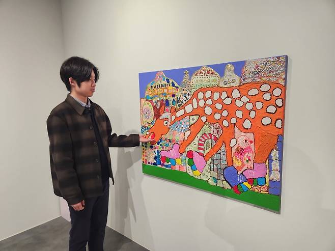 오승식 작가가 자신의 작품 앞에서 작품에 담긴 주제를 설명하고 있다.