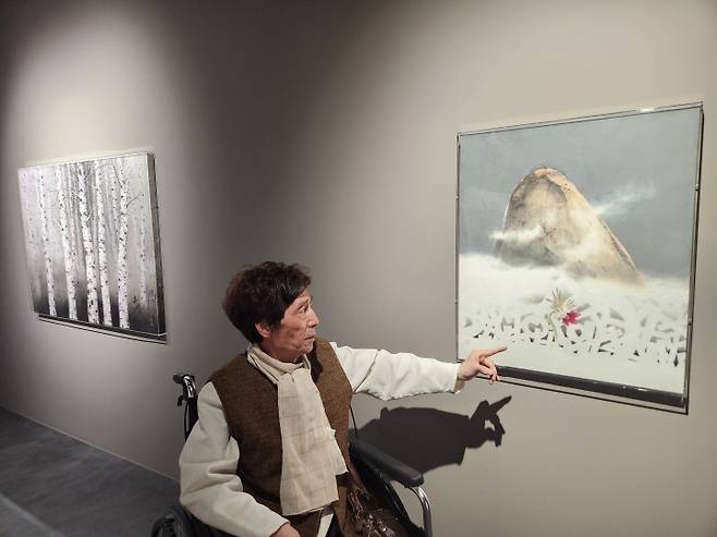 손영락 작가가 자신의 작품 앞에서 작품의 주제를 설명하고 있다.