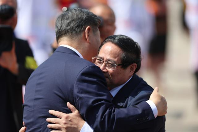 베트남 국빈방문을 마치고 말레이시아로 떠나는 시진핑(왼쪽) 중국 국가주석이 15일 하노이 노이바이 국제공항에서 팜민찐 베트남 총리와 작별 인사를 하고 있다. 하노이=AP 연합뉴스