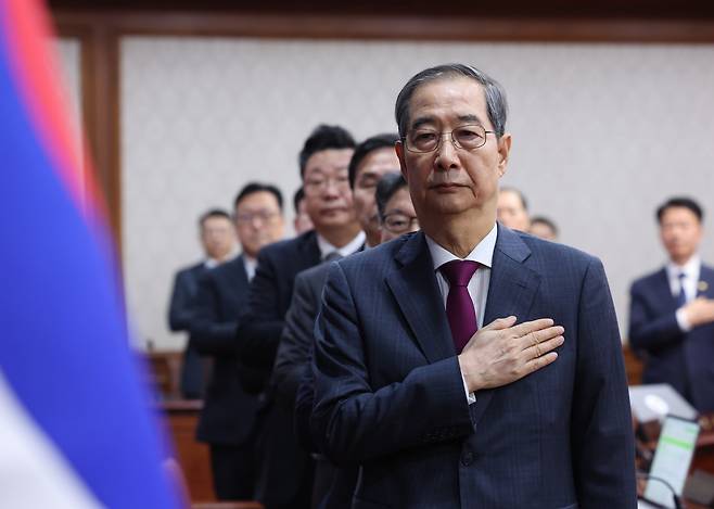 Acting President and Prime Minister Han Duck-soo salutes during a Cabinet meeting at the Government Complex in central Seoul on April 14. [YONHAP]
