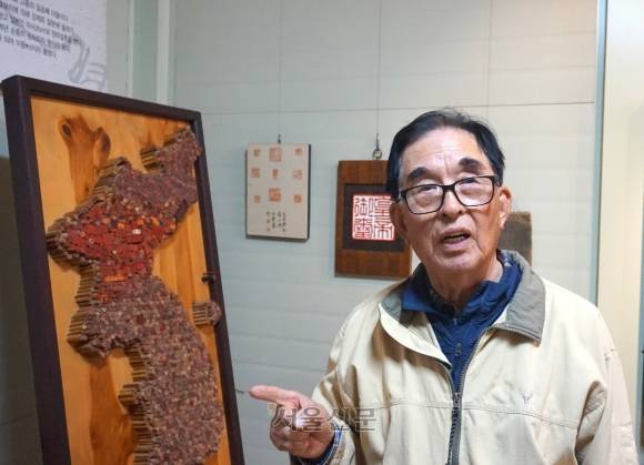 작가 이재인이 충남 예산 고향마을에 세운 한국문인인장박물관에서 관람객들이 놓고 간 막도장으로 만든 한반도 지도를 가리키고 있다.