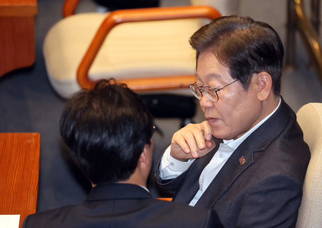 이재명 더불어민주당 대선 예비후보가 17일 국회 본회의에서 김민석 최고위원과 대화하고 있다. 연합뉴스