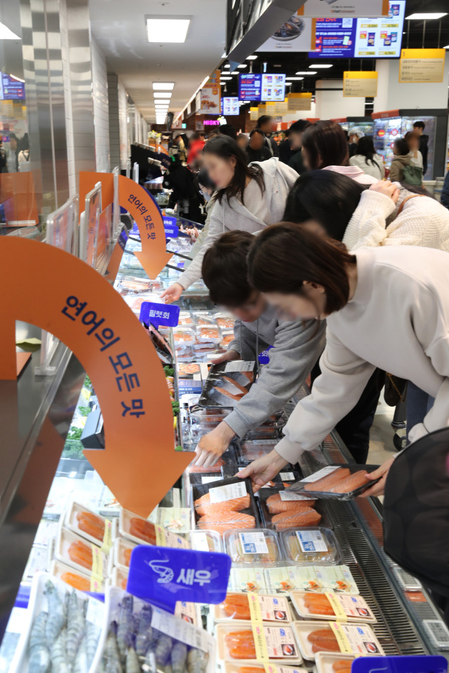 이마트가 17일 서울 강동구 고덕비즈밸리에 한층 진화한 미래형 리테일 매장 '이마트 푸드마켓 고덕점'을 그랜드 오픈했다. 사진은 고객들이 '연어의 모든 것' 코너에서 상품을 구매하고 있는 모습. 사진 제공=이마트