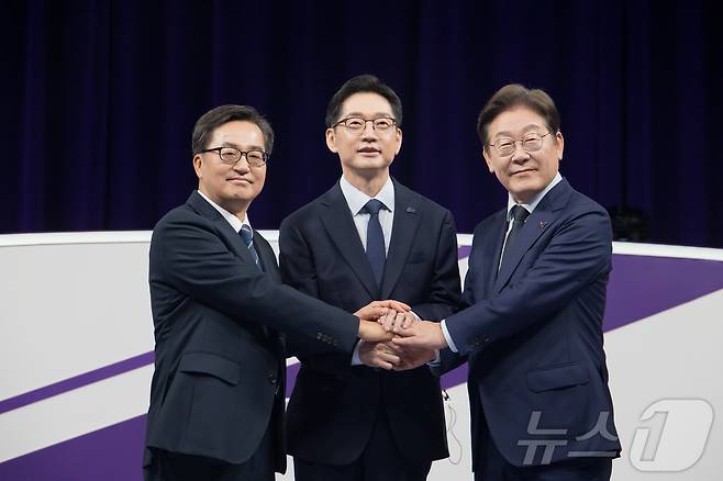 18일 저녁 상암MBC 스튜디오에서 열린 더불어민주당 대선 경선 후보자 첫 TV토론에 참석한 (오른쪽부터) 이재명, 김경수, 김동연 후보자가 손을 맞잡고 선의의 경쟁을 다짐하고 있다. 2025.4.18/뉴스1 ⓒ News1 국회사진취재단