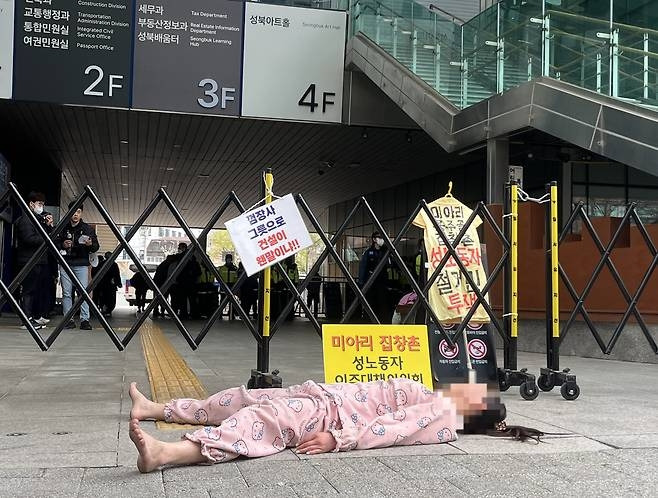 17일 서울 성북구청 앞에서 한 여성이 잠옷 차림으로 미아리 텍사스 철거에 반대하며 항의 시위를 벌아고 있다. 뉴스1