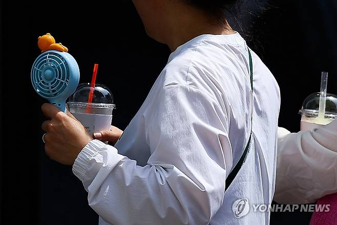 손풍기 꺼내볼까 (대구=연합뉴스) 윤관식 기자 = 영남권 일부 지역 낮 최고기온이 30도에 육박하며 초여름 날씨를 보인 18일 대구 중구 동성로에서 한 시민이 휴대용 선풍기 바람을 쐬며 이동하고 있다. 2025.4.18 psik@yna.co.kr