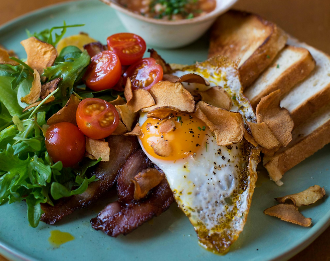 계란후라이 방울토마토 베이컨 식빵이 올라가있는 브런치 접시