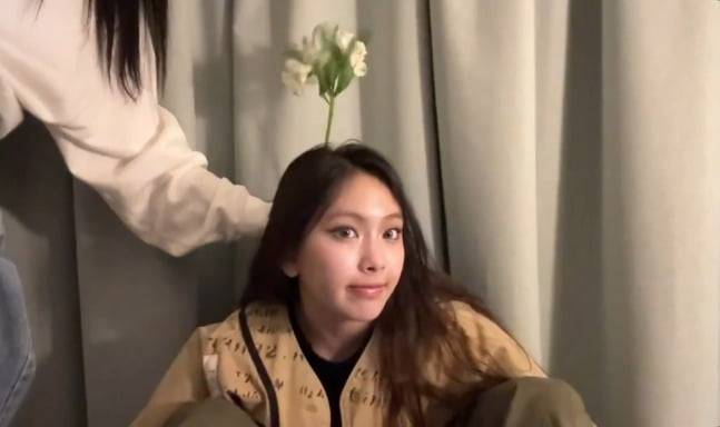 피크민 게임을 즐기는 뉴진스 멤버 혜인. 머리에 꽃이 자라난 듯한 '피크민샷' 포즈를 취하고 있다.  /사진=뉴진스 라이브 방송 캡처