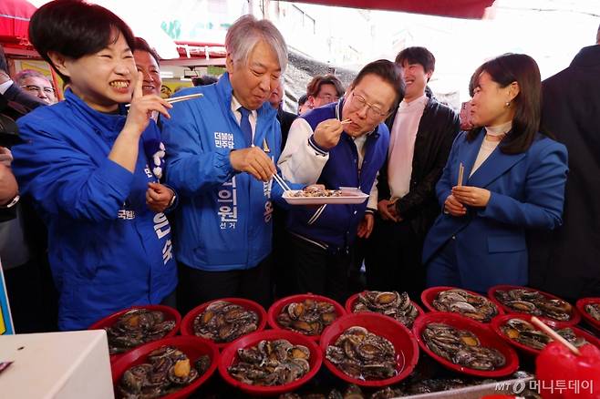 [부산=뉴시스] 하경민 기자 = 이재명 더불어민주당 대표가 15일 부산 기장군 기장시장을 방문, 지역 총선 후보들과 해산물을 맛보고 있다. (공동취재) 2024.03.15. photo@newsis.com /사진=편집부