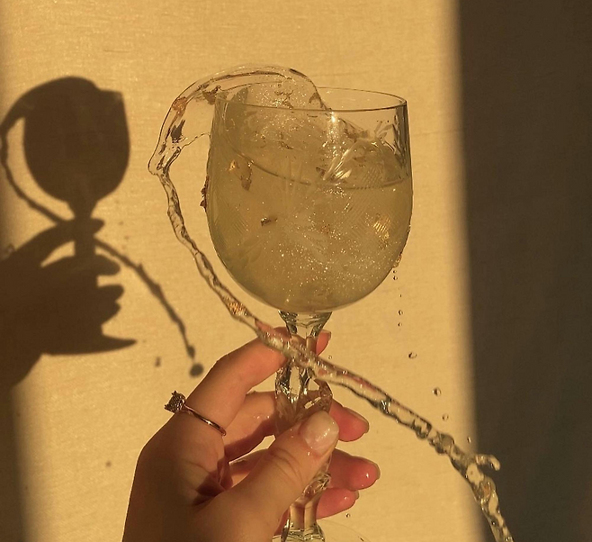 와인잔에 들어있는 옅은 노란색의 음료