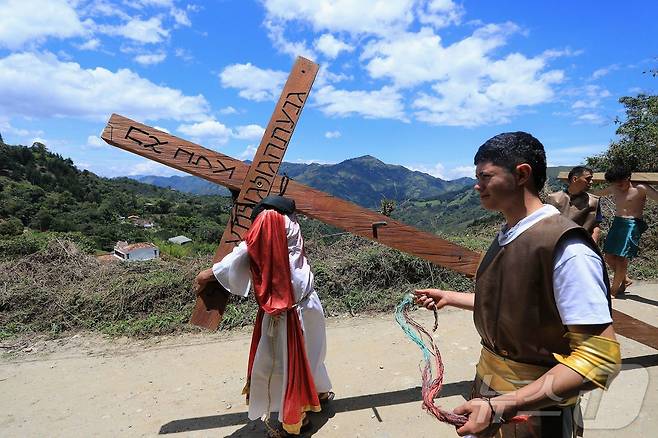 18일(현지시간) 콜롬비아 안티오키아주 엘 레티로에서 열린 성금요일 행사에서 십자가를 든 예수 행렬이 이동하고 있다. ⓒ AFP=뉴스1