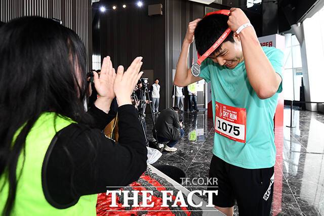 완주에 성공한 참가자가 메달을 목에 걸고 있다.