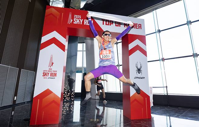 20일 오전 서울 송파구 롯데월드타워에서 열린 '2025 롯데월드타워 스카이런 with SPYDER'에서 한 참가자가 결승선을 통과한 뒤 기념 촬영을 하고 있다./뉴스1