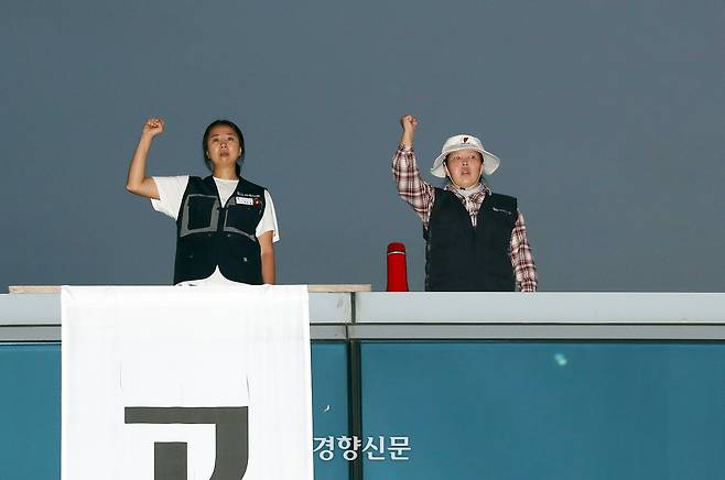 고용승계를 요구하며 공장 옥상에 올라 고공농성을 벌이고 있는 한국옵티칼하이테크 해고 노동자 박정혜(왼쪽), 소현숙씨가 지난해 10월 16일 저녁 열린 약식집회에서 구호를 외치고 있다. 정지윤 선임기자