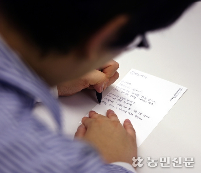 마음속 그 사람에게 줄 정호승 시인의 시를 필사하는 참가자.