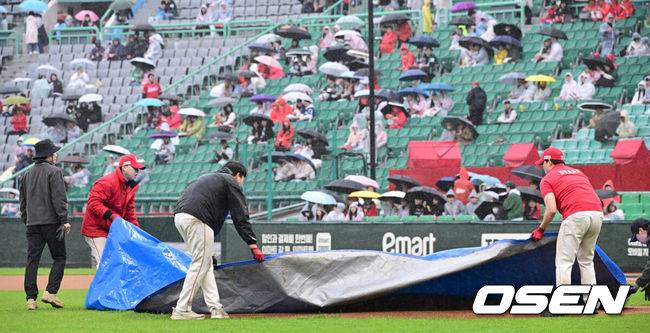 [OSEN=인천, 최규한 기자] 19일 오후 인천 SSG랜더스필드에서 ‘2025 신한 SOL Bank KBO리그’ SSG 랜더스와 LG 트윈스의 경기가 열렸다.이날 홈팀 SSG은 송영진, 방문팀 LG는 손주영을 선발로 내세웠다.1회초 1사 1루 상황에서 우천으로 경기가 중단됐다. 마운드에 방수포를 덮는 SSG 그라운드 관리 요원들. 2025.04.19 / dreamer@osen.co.kr