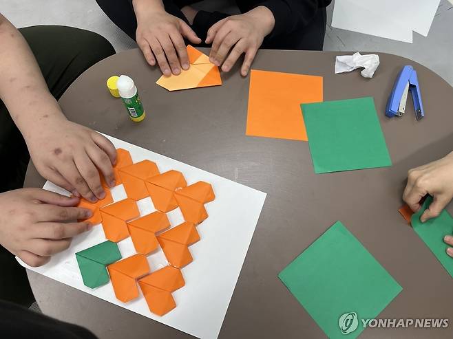 '종이로 만드는 하트' (서울=연합뉴스) 오인균 인턴기자 = 지난 1일 서울의 한 장애인복지관에서 발달 장애인 당사자가 종이접기를 하고 있다. 2025.04.20