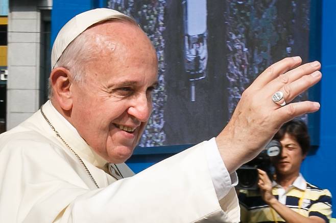 프란치스코 교황이 2014년 8월 16일 방한 당시 서울 광화문광장에서 열린 '윤지충 바오로와 동료 123위 시복미사'에 참석하기 위해 시청에서 광화문까지 카퍼레이드를 하며 천주교 신자들을 향해 손을 들어 인사하고 있다./뉴스1