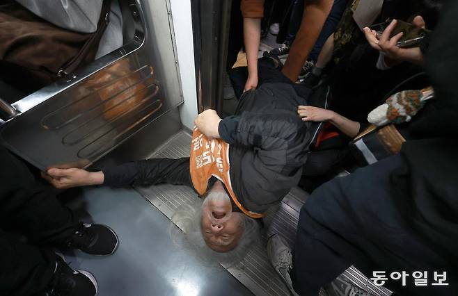 박경석 전국장애인차별철폐연대(전장연) 공동대표가 21일 서울 지하철 4호선 혜화역에서 출근길 지하철 탑승 시위 도중 열차로 진입하고 있다. 송은석 기자 silverstone@donga.com