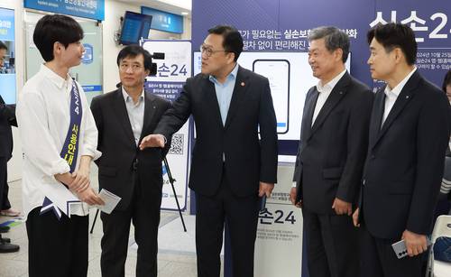 서울 여의도 성모병원에서 김병환 금융위원회 위원장이 실손청구 전산화 홍보 부스에 방문해 현장 안내직원의 설명을 듣고 있다.(사진=금융위원회)