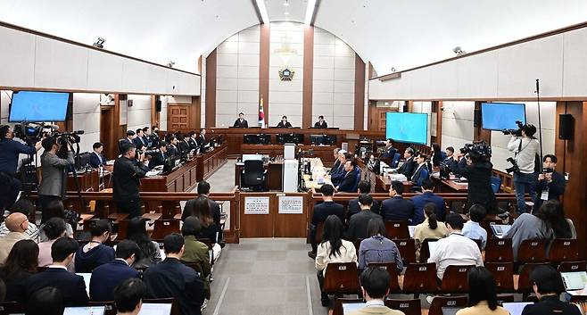 12·3 비상계엄을 선포해 내란 우두머리 혐의로 재판에 넘겨진 윤석열 전 대통령과 변호인들이 21일 오전 서울 서초구 서울중앙지법 417호 법정 피고인 쪽에 앉아 재판 시작을 기다리고 있다. 사진공동취재단